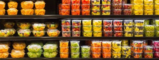 Assortment of cut fruit in plastic containers on display for sale at the supermarket