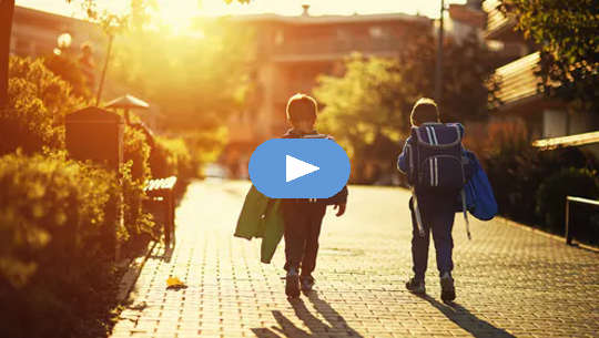 two young boys walking down the street by themselves