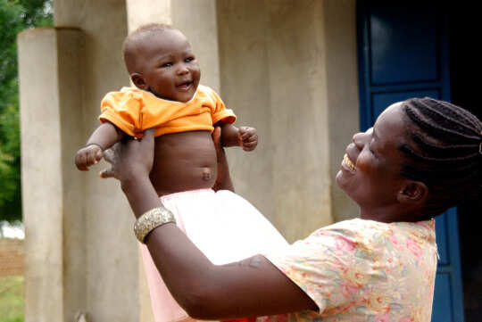 mother holding up a baby