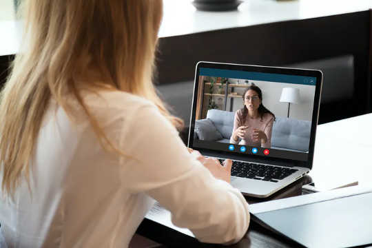 Young woman talking to woman on video call