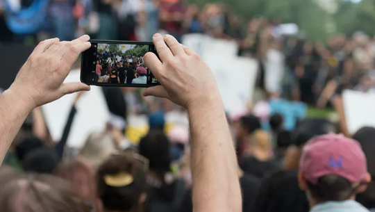 someone taking a picture in a crowd