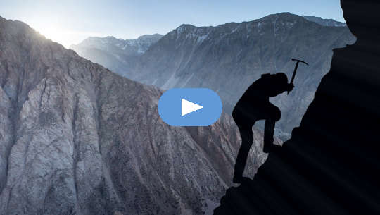 photo silhouette of mountain climber using a pick to secure himself