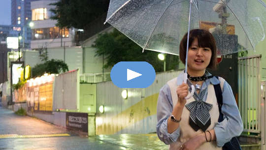 Smiling young girl walking with open umbrella