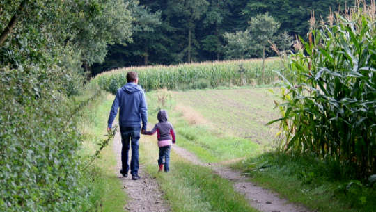 child walking holding an adult's hand