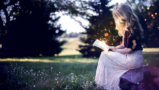 woman sitting outside reading a book