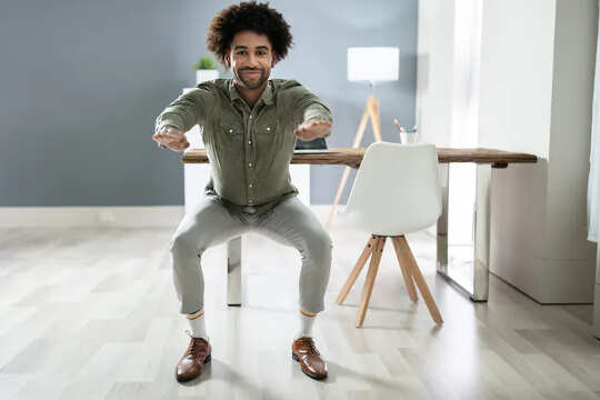 man standing in a semi-squatting position indoors