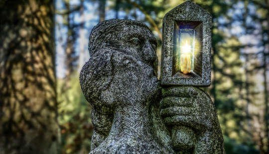 stone sculpture of a man and woman holding up a lantern