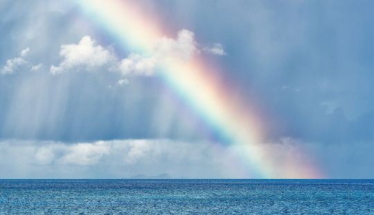 a rainbow shining down into the water