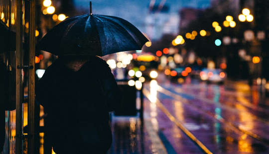 an adult's shadow at night under the city lights