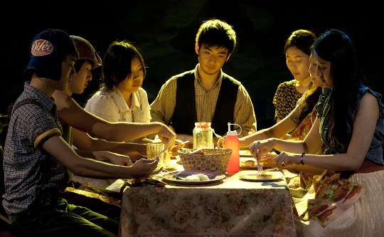 a group of people sitting around a table sharing a meal