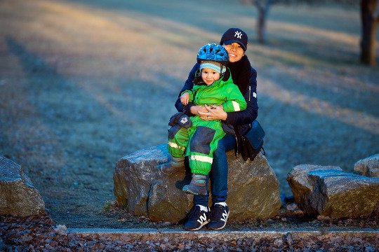 a child sitting on his mother's lap - both are smiling