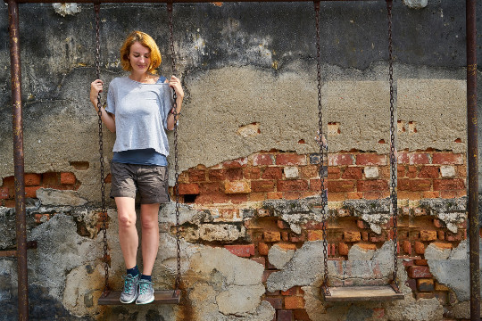 smiling woman standing on a swing