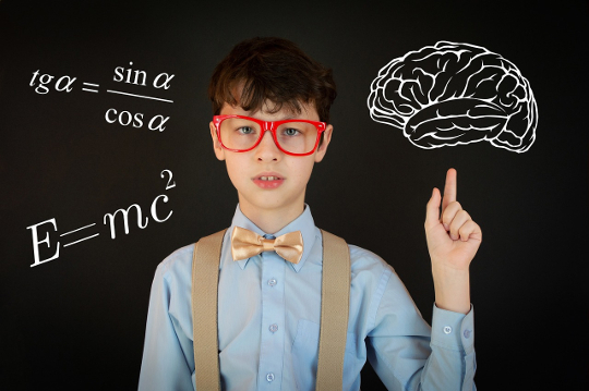 young boy in front of a blackboard