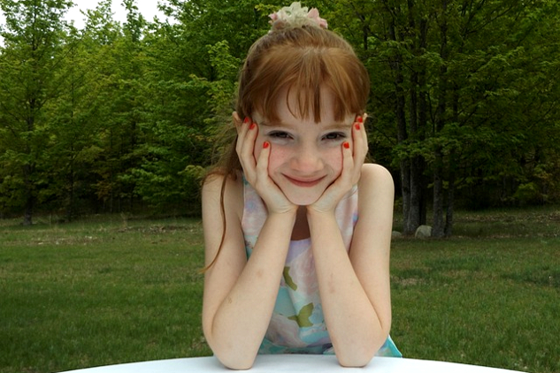 young girl listening attentively to the person in front of her