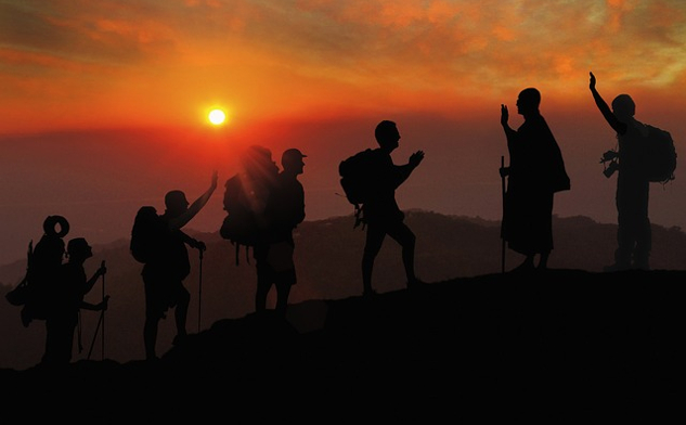 hiker greeting a monk with namaste on a walking trail