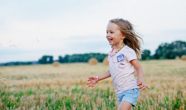 young girl running joyfully in a meadow