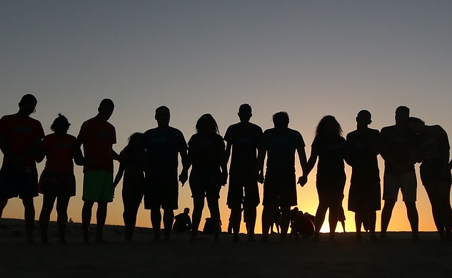 a group of people in line at the horizon, holding hands