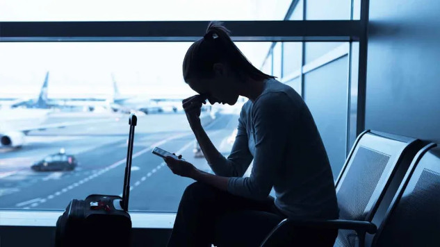 An airport terminal with travelers waiting for flights, showing the importance of having strategies to cope with flight delays and cancellations.