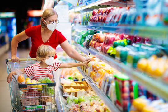 Mother and child shop for vegetables at the supermarket.