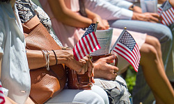 people sitting in a stadium holding small flags in their hands