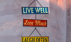 a sign that says: Live Well, Love Much, Laugh Often