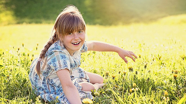 radiant young girl in an equally radiant meadow