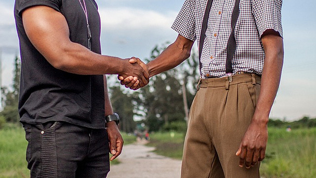 two men from different backgrounds shaking hands