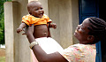 mother holding up a baby