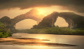 two natural archways on the other side of an expanse of water