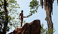 a young boy climbing to the top of a rock formation