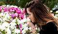 a woman smelling a bush of roses