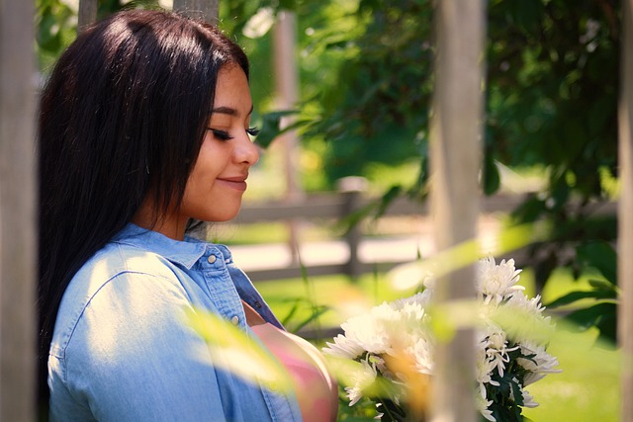 a smiling woman looking at some flowers