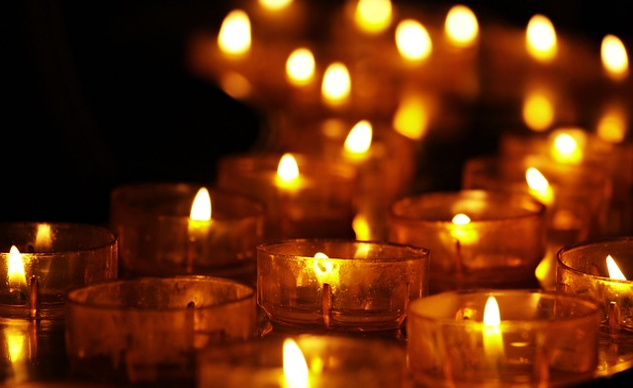 a group of lit votive candles