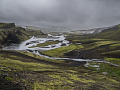 a river flowing around rocks and small islands