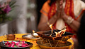 a person in meditation in front of a bowl of flower petals and a bowl of fire