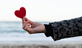 a hand reaching out and presenting a heart